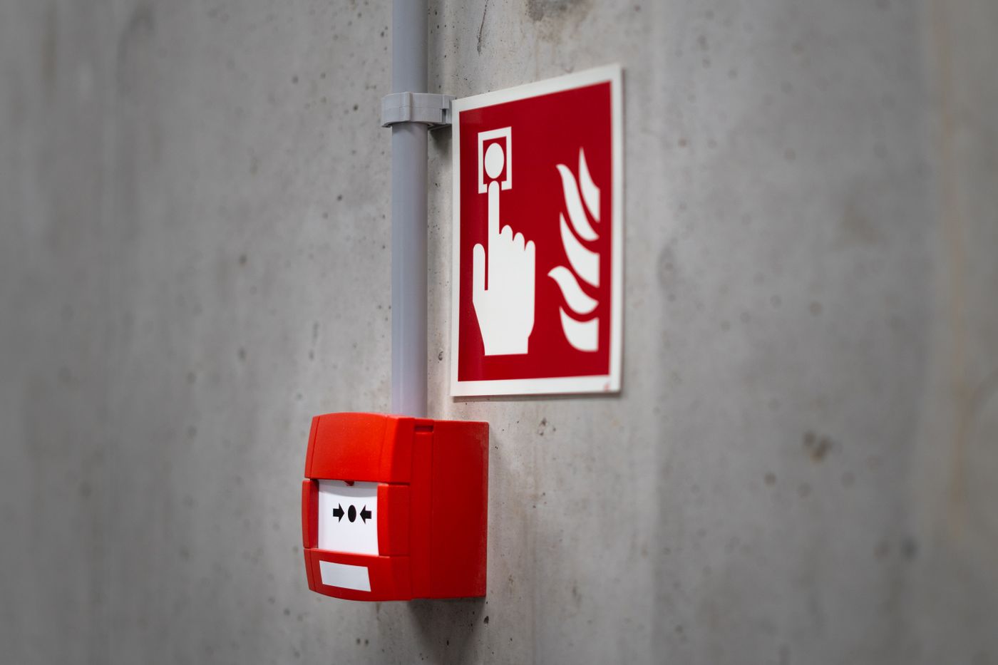 Acionador manual vermelho com placa de identificação na parede